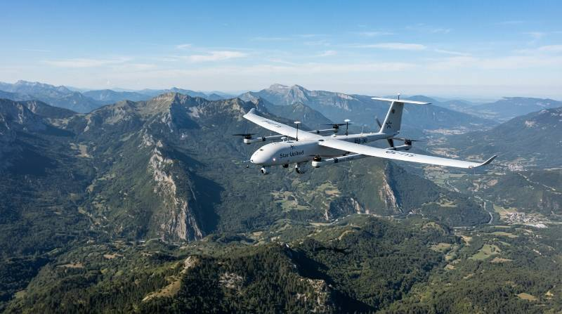 industrial VTOL fixed wing UAV cruising over mountainous terrain during long endurance survey flight